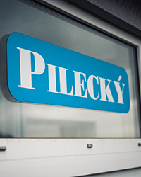Reklamní polep Pilecký na skleněném okně